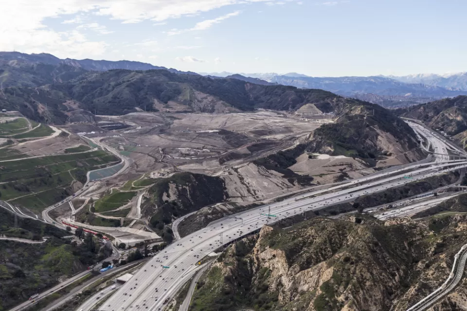 Aerial view of I-5 freeway and large landfill in hilly part of Los Angeles County